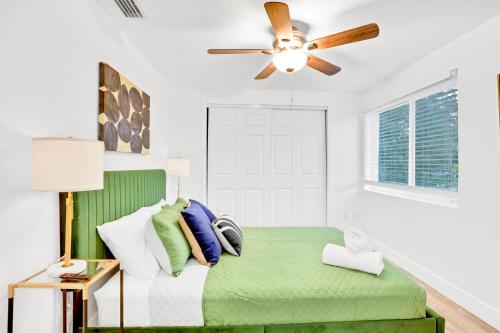 a bedroom with a green bed with a ceiling fan at Blue on Fox Run in Apollo Beach