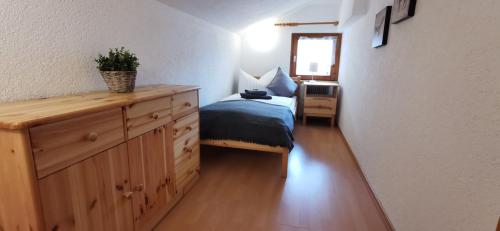 a bedroom with a bed and a dresser with a plant on it at Haus Tisch in Schruns-Tschagguns