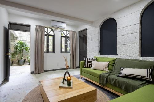sala de estar con sofá verde y mesa en Sleeps 9, Outdoor Space, PingPong Table, in Villa, en Oaxaca City