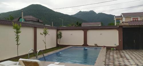 ein Schwimmbad mit Bergen im Hintergrund in der Unterkunft Family villa in Qabala in Qəbələ