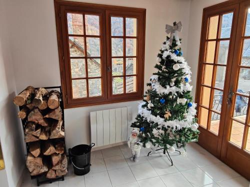 a christmas tree in a living room with a cat at CHALET BOUTX 6 PERSONNES in Boutx