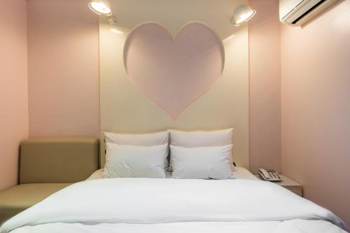 a bedroom with a large heart on the wall at Laria Hotel in Suwon