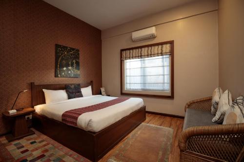 a bedroom with a bed and a window and a couch at Shaligram Hotel in Pātan