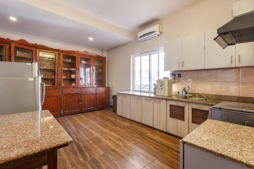a large kitchen with wooden floors and wooden cabinets at Shaligram Hotel in Pātan