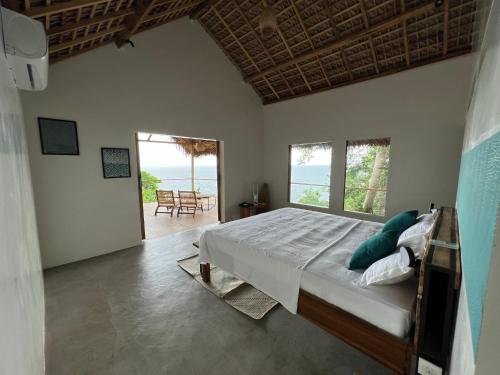 Canopee Lodge في Nosy Komba: غرفة نوم مع سرير وإطلالة على المحيط