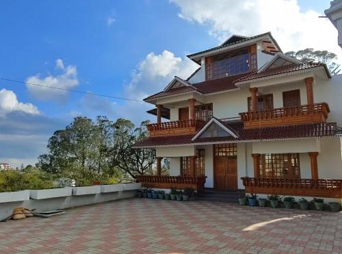 a house with a brick courtyard in front of it at Pears Garden Royal Suite in Kodaikānāl