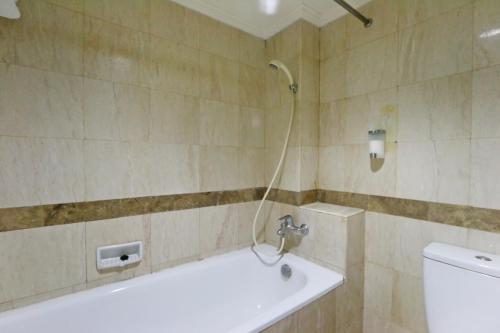 a bathroom with a shower with a sink and a toilet at Hotel Kaisar in Jakarta