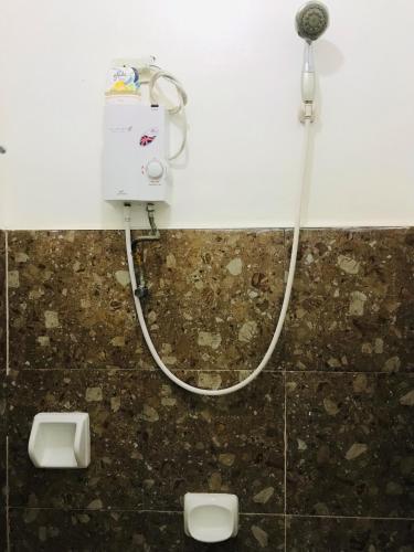 eine Dusche im Bad mit zwei Urinalen in der Unterkunft Queen's Room Rental 3 in El Nido