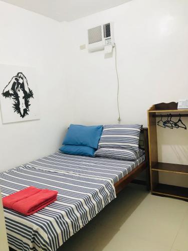 een bed in een kamer met een rode handdoek erop bij Queen's Room Rental 3 in El Nido