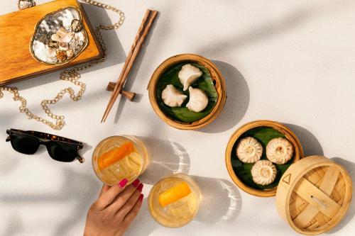 a person holding a drink next to bowls of food at Hyatt Hyderabad Gachibowli in Hyderabad