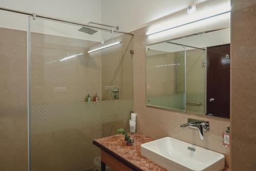 a bathroom with a sink and a shower with a mirror at Sinclairs Gangtok in Gangtok