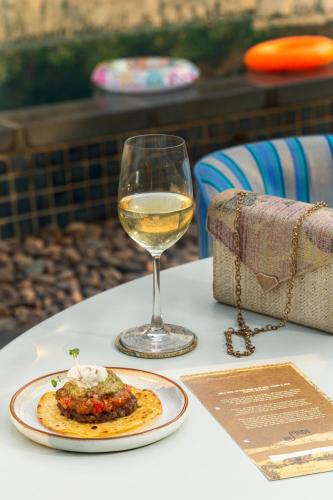 a glass of white wine sitting next to a plate of food at Hyatt Hyderabad Gachibowli in Hyderabad