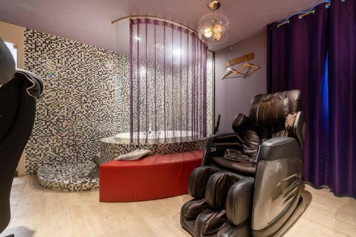 a dressing room with a chair and a shower at Laria Hotel in Suwon