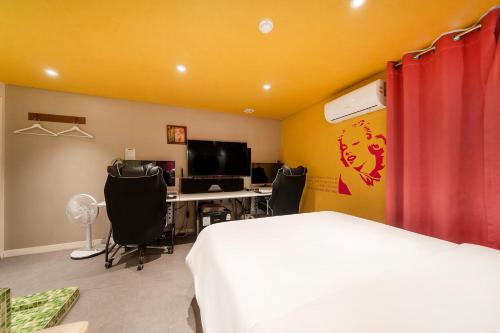 a bedroom with a bed and a desk with a computer at Laria Hotel in Suwon