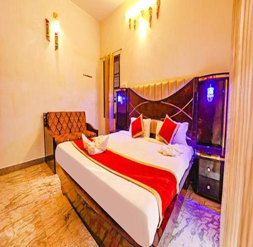 um quarto com uma cama grande e um cobertor vermelho em FabEscape Queens Paradise em Pondicherry
