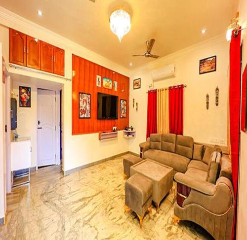 ein Wohnzimmer mit einem Sofa und einem Tisch in der Unterkunft FabEscape Queens Paradise in Puducherry