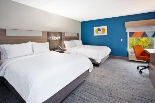 a hotel room with two beds and a desk at Holiday Inn Express Hotel & Suites Dover by IHG in Dover