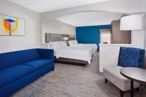 a hotel room with a bed and a blue couch at Holiday Inn Express Hotel & Suites Dover, an IHG Hotel in Dover