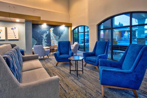 a waiting room with blue chairs and a table at Holiday Inn Express Hotel & Suites Dover by IHG in Dover