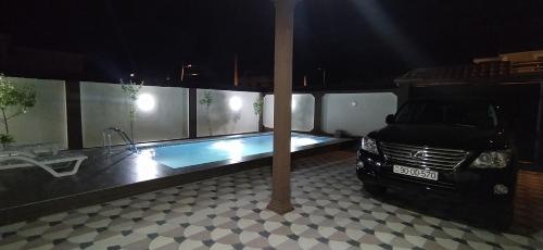 ein Auto, das in einer Garage mit Pool geparkt ist in der Unterkunft Family villa in Qabala in Qəbələ