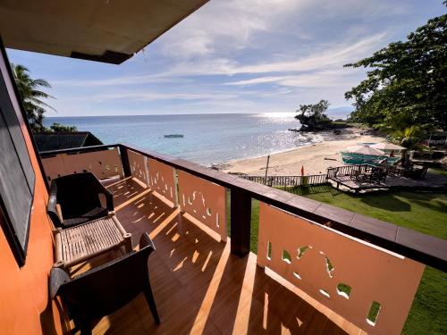 a balcony with benches and a view of a beach at 1peace beach resort in Anda