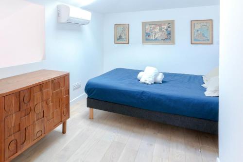 une chambre avec un lit avec des draps bleus et une commode dans l'établissement 2BR Close Gare Station AC and Balcony DOWNTOWN CANNES - BENAKEY, à Cannes