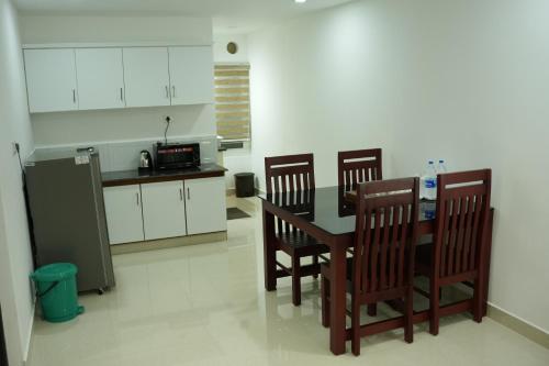 a kitchen with a table and four chairs and a counter at RJ ROSS RAMAPURAM in Munnar