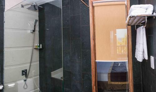 a bathroom with a shower with a glass door at Sonata Resort & Spa in Phan Thiet