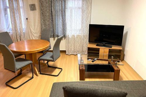 sala de estar con mesa y TV de pantalla plana en City apartment with Wifi near Jena, en Kahla