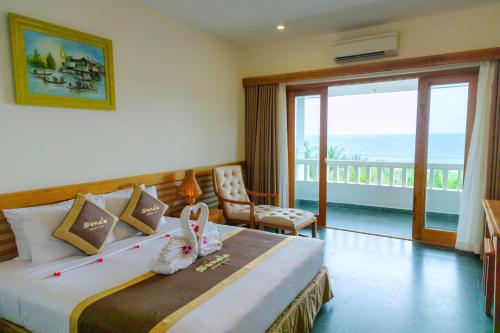 a bedroom with a bed with a view of the ocean at Sonata Resort & Spa in Phan Thiet