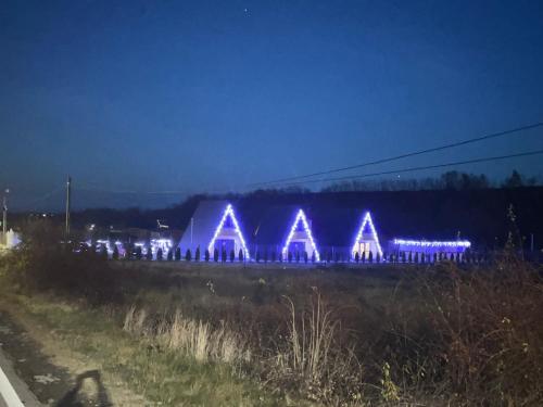 a building with blue lights on it at night at Liniștea Muntilor Cartioasra in Cîrţişoara