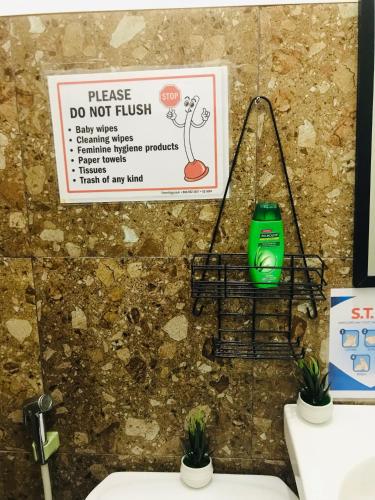 um sinal numa parede acima de um lavatório com plantas em Queen's Room Rental 4 em El Nido