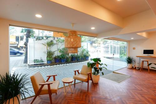 a lobby with chairs and a table and some plants at Bloom Boutique - Bandra in Mumbai