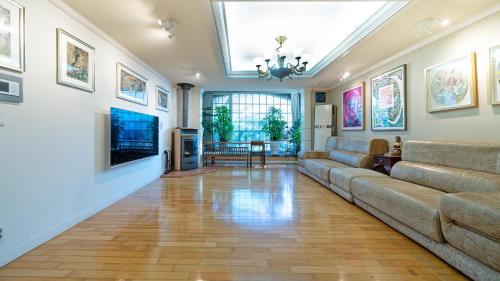 a living room with a couch and a television at Museum Stay in Yongin