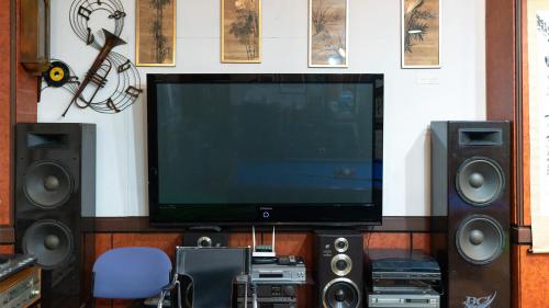 a flat screen tv sitting on a wall with speakers at Museum Stay in Yongin