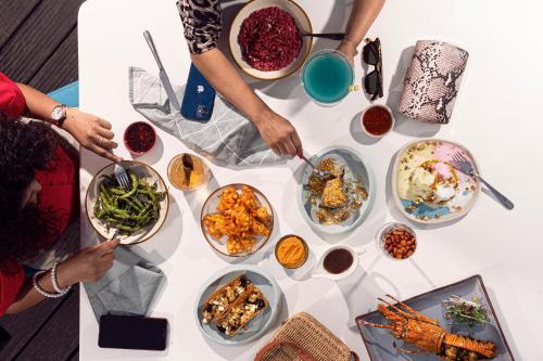a group of people standing around a table with bowls of food at Hyatt Hyderabad Gachibowli in Hyderabad