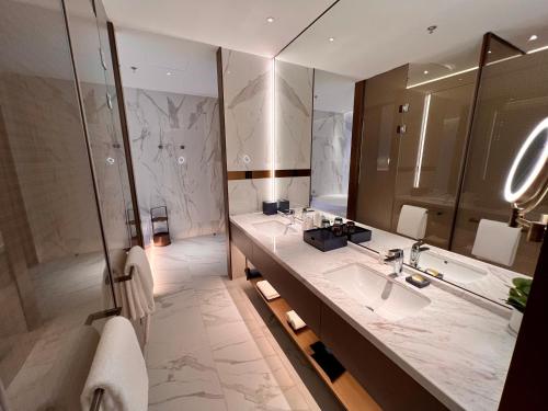 a bathroom with a sink and a tub and a mirror at Wyndham Shanxi Xiaohe Xincheng in Taiyuan