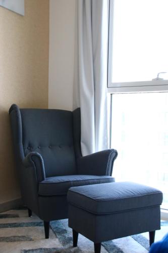 a blue couch and a ottoman in front of a window at ZAPBED House - Luxury Holiday Homes in Yas Island in Abu Dhabi