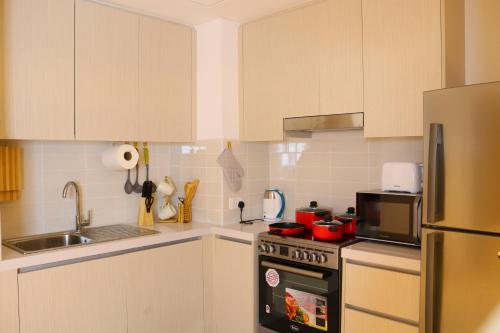 a kitchen with white cabinets and a stove top oven at ZAPBED House - Luxury Holiday Homes in Yas Island in Abu Dhabi