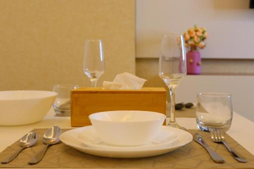 a table with two wine glasses and a plate and spoon at ZAPBED House - Luxury Holiday Homes in Yas Island in Abu Dhabi
