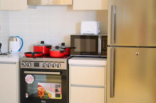 a kitchen with a stove and a refrigerator at ZAPBED House - Luxury Holiday Homes in Yas Island in Abu Dhabi