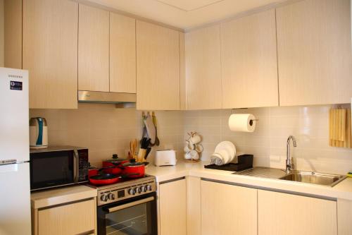 a kitchen with white cabinets and a stove top oven at ZAPBED House - Luxury Holiday Homes in Yas Island in Abu Dhabi