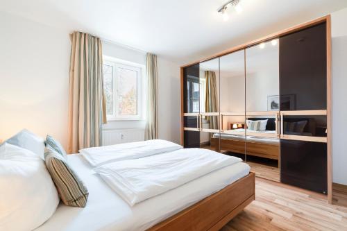 a bedroom with a large bed with a large mirror at Wohnpark am Mühlenteich App 33 Ostseeluft in Timmendorfer Strand