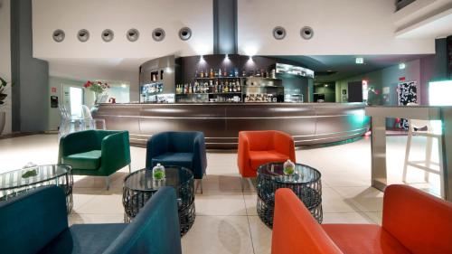 a restaurant with colorful chairs and a bar at Holiday Inn Nola - Naples Vulcano Buono by IHG in Nola