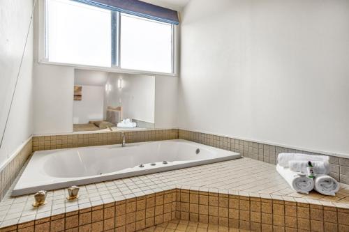 a bath tub in a bathroom with a window at Capital Lodge Motor Inn in Wellington