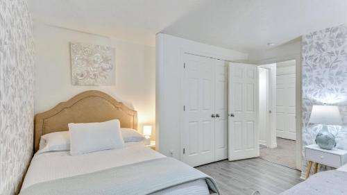 a white bedroom with a large bed and white walls at Play & Gather in Luxury,Pets too! Close to it Everything! in Orem