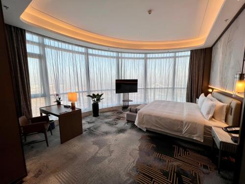 ein Hotelzimmer mit einem großen Bett und einem Schreibtisch in der Unterkunft Wyndham Shanxi Xiaohe Xincheng in Taiyuan