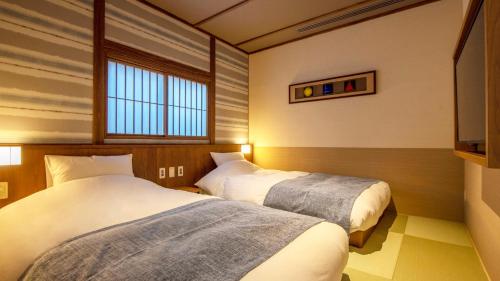 a room with two beds and a window at Shionoyu Onsen Rengetsu in Nasushiobara