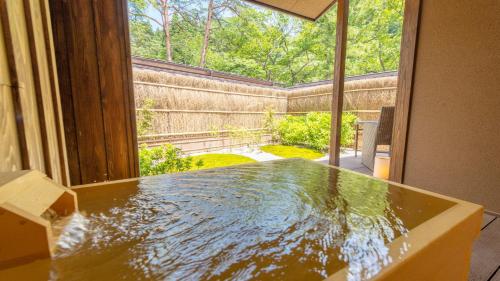 a table in a room with a view of a garden at Shionoyu Onsen Rengetsu in Nasushiobara