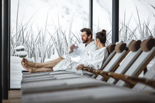 a man and a woman sitting in a spa tub at SKI - GOLF - WELLNESS Hotel Riml in Hochgurgl